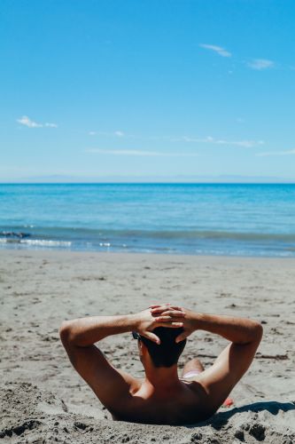 Man sun tanning on the beach during the Summer